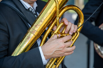 man playing  brass tuba in street music band performing at outdoor festival