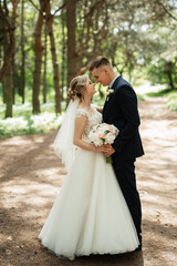 the groom and the bride are walking in the forest