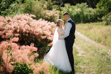 the groom and the bride are walking in the forest