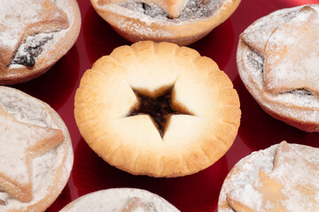 Fototapeta na wymiar Traditional Christmas mince pies are arranged on a colourful red plate.