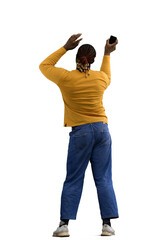 A man in a yellow jacket on a White background waves a phone, back view