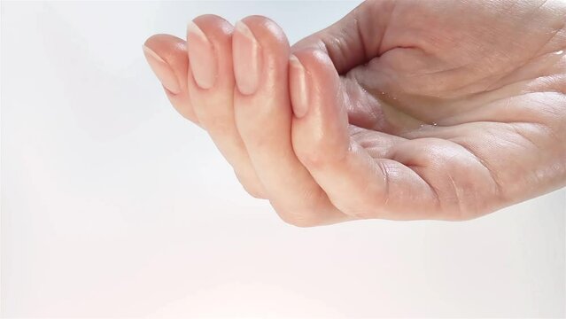 Natural essential oil drops from the pipette on the woman's palm. Close-up view. Organic aroma massage oil, hyaluronic acid serum, or ayurvedic cosmetics oil for hair, skin, or body ad