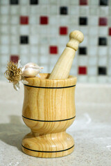 close-up of a wooden garlic mortar and whole garlic,