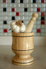 close-up of a wooden garlic mortar and whole garlic,close-up of a wooden garlic mortar and whole...