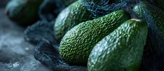 Fotobehang Avocados on grocery produce store shop supermarket display raw unripe tropical green fruit in mesh net bags. Creative Banner. Copyspace image © HN Works