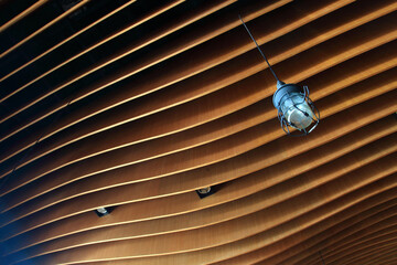 Wooden plank artwork for ceiling with hanging lamp.