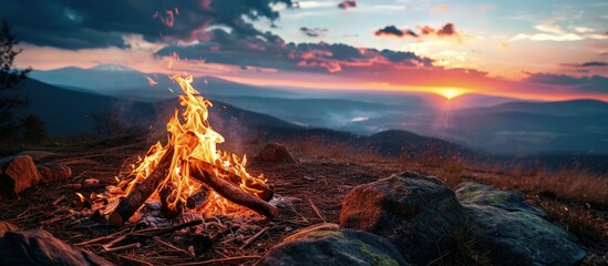 Bonfire on a background of the sky in the mountains. Creative Banner. Copyspace image - obrazy, fototapety, plakaty