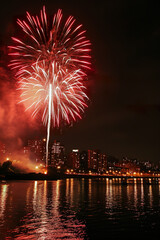 Fototapeta premium Fireworks over a city skyline, Fourth of July theme, copy space