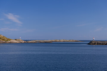 A tranquil Norwegian Sea with two lighthouses standing guard on the rocky shores of the Lofoten Islands, basking in the Nordic sunlight