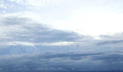 Gray clouds cover white and bright sky background.