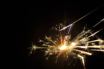Obraz premium Golden sparkler on black. Bright sparklers on black background closeup