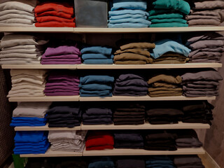 the wardrobe with shelves is clearly divided by color and type of clothing. shirts with collars in...