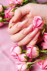 Female hands with pink nail design  hold pink roses