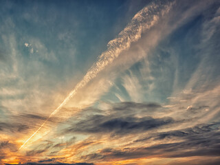 Dramatic nature scene with blue sunset sky and a trace of airplane or missile. Warm and cool tone....