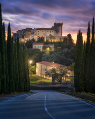 Rosignano Marittimo castle and village view from a cypress road at sunset. Tuscany, Italy