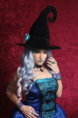 Woman Dressed as Blue Witch on Red Background