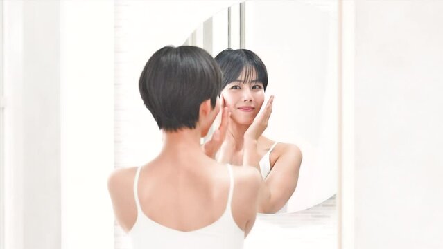 Animation of a beautiful woman looking in the mirror at a washbasin that is easy to use with images of beauty, etc., and touching her cheeks for the camera.