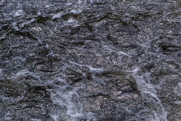 Close up detail of fierce white water river rapids from a clean deep green colored river forming a...