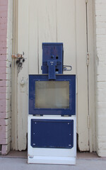 Empty Newspaper Vending Machine on Sidewalk near store building
