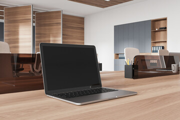 Coworking interior with workspace, black laptop display on wooden desk