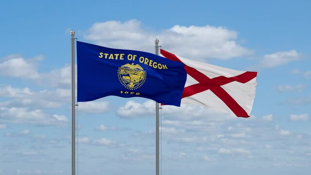 Alabama and Oregon US state flags waving together on cloudy sky, endless seamless loop