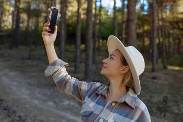 female tourist holds in her hand a smartphone search signal in the forest. Communication, problems...