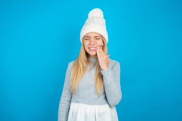 beautiful caucasian teen girl wearing grey sweater touching mouth with hand with painful expression...