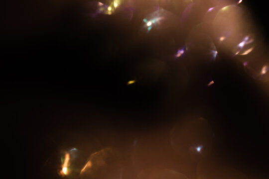 Blur colorful gold crystal light leaks on black background. Defocused abstract red and orange retro film lens flare bokeh analog photo overlay or screen filter effect. Glow Vintage prism warm colors