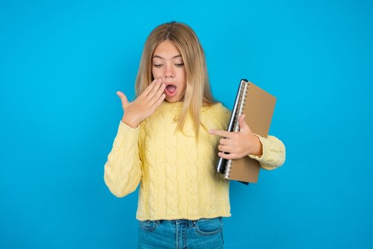 Shocked beautiful caucasian teen girl  look surprisedly down, indicates at blank  with fore finger, Scared model