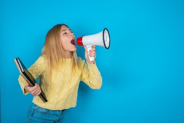 beautiful caucasian teen girl wearing yellow sweater  Through Megaphone with Available Copy Space