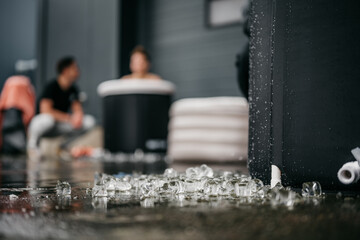 Ice blocks fallen out of ice bath with blurry people in background doing an ice bath challenge