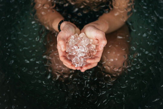 Holding a handful of ice blocks in an ice bath.