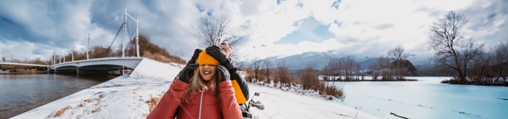 Fototapeta na wymiar A romantic couple shares a tender embrace and kisses while joyously riding a quad through the snowy landscape, creating a magical and passionate moment amidst the wintry adventure