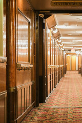 Wooden paneled cabin corridor hallway aisle to staterooms and suites onboard legendary ocean liner...