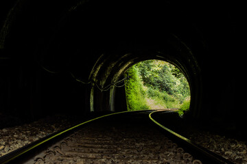 Dudhsagr,Goa-6th October 2023:Railway tracks passing through the tunnel in the dark with exit light.
