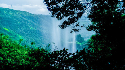 View of Baba waterfall, a natural cascade of beauty surrounded by lush greenery, Maharashtra, India.
