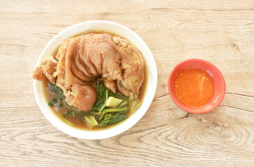 boiled slice pork leg and foot with Chinese kale in black herb soup on plate dipping chili sauce