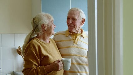 Happy senior man drinking tea with his wife in the morning