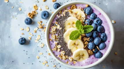 Fotobehang Сlose-up of a healthy vegan breakfast. A plate with healthy superfood - fresh berries, fruit yogurt, chia seeds, granola and banana slices on pastel table.  © dinastya