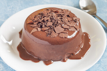 Chocolate dessert Panna Cotta on white plate, horizontal closeup