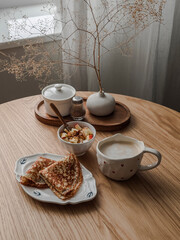 Cozy morning - breakfast, brunch on a wooden table - crepes, yogurt with granola and apple, cappuccino