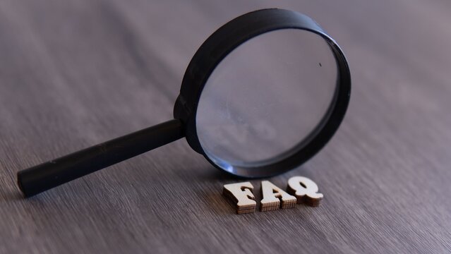Closeup image of magnifying glass and word FAQ, FREQUENTLY ASKED QUESTION.