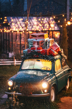 a green car with gifts on the roof on a background of light bulbs. a ready-made Christmas decoration for a family photo shoot. an old car in a photo shop for making Christmas photos