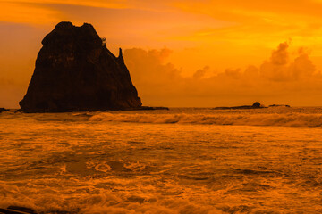Sunset at the rocky beach in Papuma, Jember, East Java, Indonesia - obrazy, fototapety, plakaty