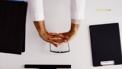 The hands of a man at the desk are doing a little muscle stretching. The idea of starting a workflow