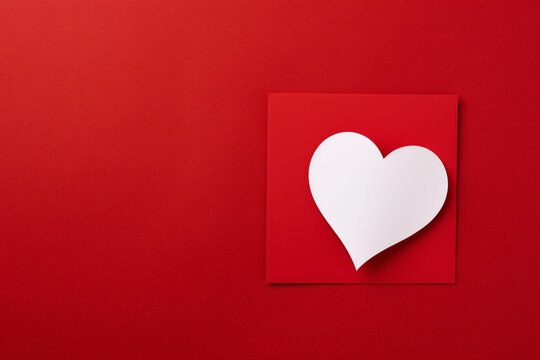 a blank sheet of paper and a heart on a red background