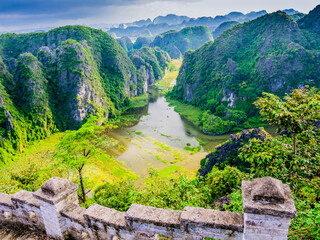 Impressive karst formations and rice paddy fields in Tam Coc with the stone staircase ascending the lying dragon in foreground, Ninh Binh province, Vietnam
- 700658089