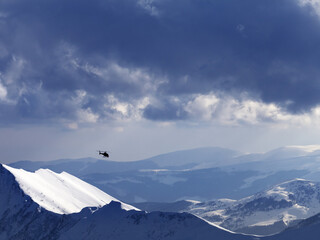 Off-piste slope for heliskiing and helicopter in evening