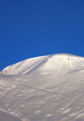 Off-piste slope and blue cloudless sky in nice winter morning - 700666401