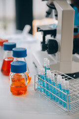 biochemical research scientist team working with microscope for coronavirus vaccine development in pharmaceutical research labolatory, selective focus